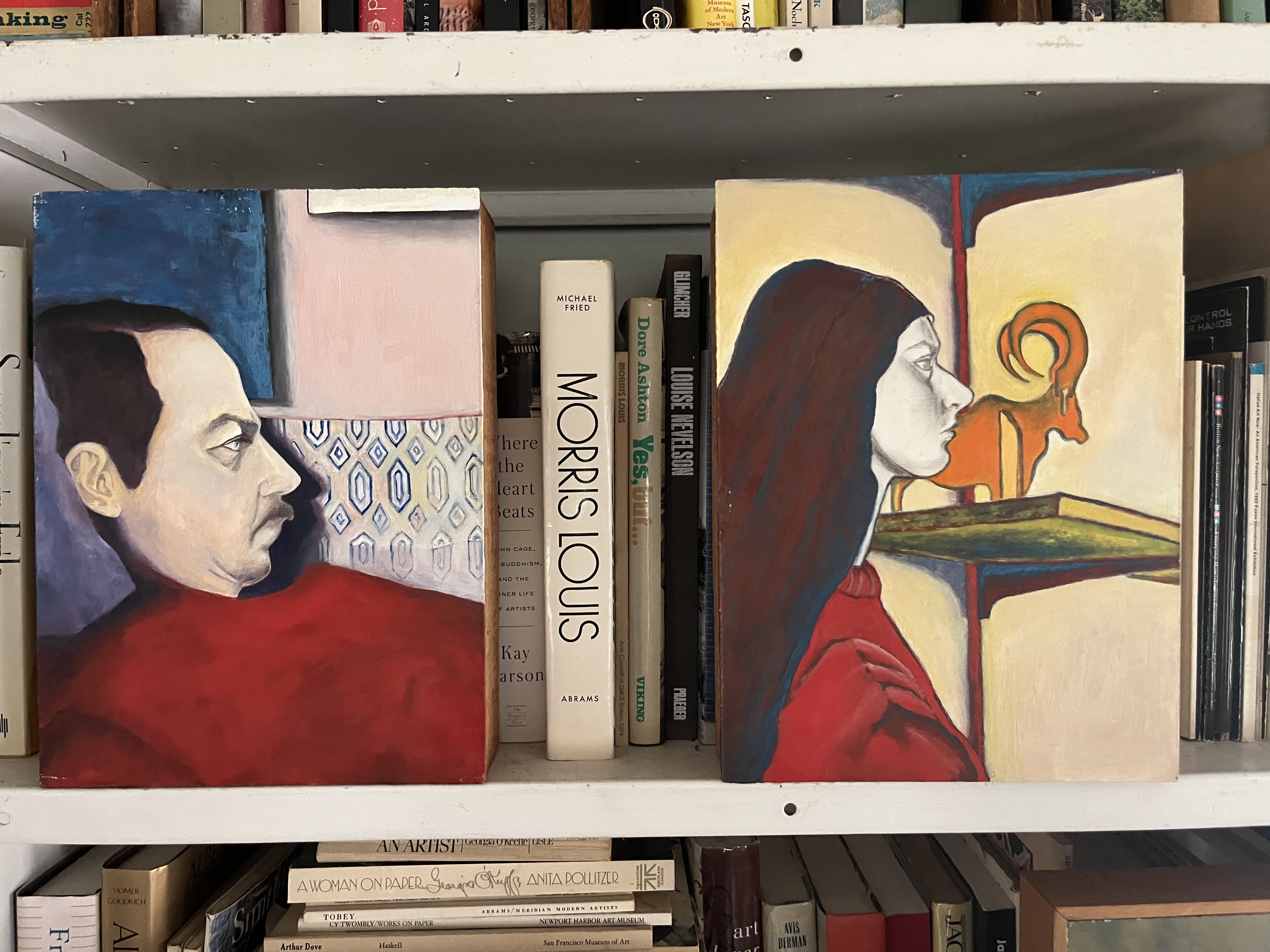 Living room bookshelves with portraits and art books
